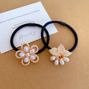 Elegant black elastic hair ties with gold floral motifs and white faux pearls
