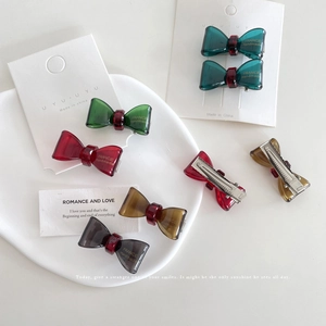 Minimalist acetate bow hair clip in vintage colors with a silver metal duckbill grip