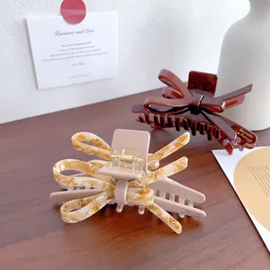 Pince à cheveux élégante en acétate avec nœud aux motifs ambre et marbre chic