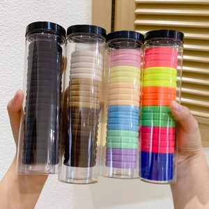 Set of four jars with assorted color elastic hair bands in transparent storage containers