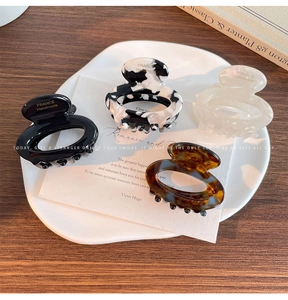 Detail of handmade acetate hair claws in floral, marble, and tortoiseshell patterns