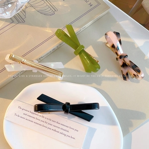 Minimalist acetate bow hair clips in multiple colors with golden metal alligator base