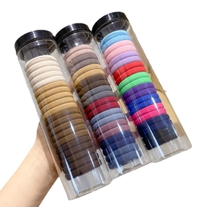 Three tubes of colorful high-elastic hair ties in various neutral and bright shades