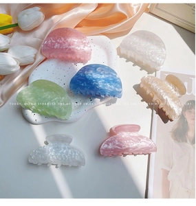 Primer plano de pinzas para el cabello jaspeadas en tonos rosa pastel, azul y crema