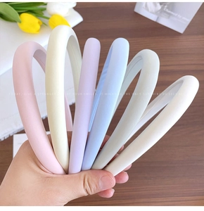 Close-up showing a set of six colorful padded satin headbands with smooth fabric texture