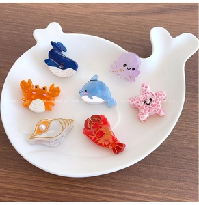 Detailed set of ocean-themed acetate hair claws including whale and starfish designs