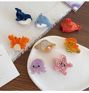 Overview of eight colorful acetate hair clips featuring various marine animal shapes