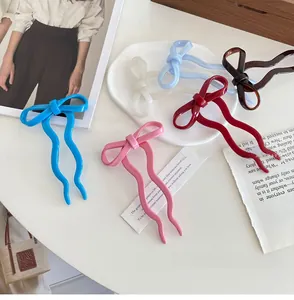 Close-up of ballet-style bow hairpins in multiple vibrant colors on a white tray
