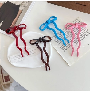 Chic ballet-style bow hair pins in four colors displayed on a white decorative tray