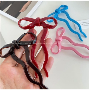 Close-up of ballet-style bow hairpins in resin with tortoise, red, pink, and blue colors