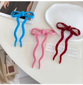 Detailed view of colorful bow hairpins in blue, pink, and burgundy with glossy finish
