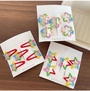 Colorful star and flower hair clips displayed on a wooden table for children
