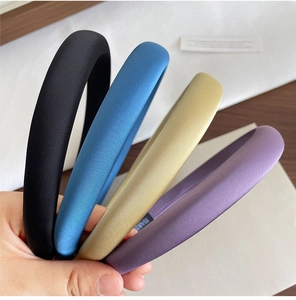 Texture dettagliata di cerchietti spessi in raso imbottito in nero, blu, oro e viola