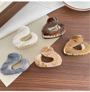 Set of five hollow heart-shaped acetate hair claws in marble and tortoiseshell patterns