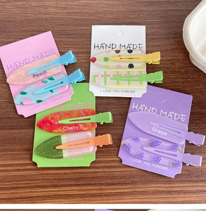 Détail des barrettes à cheveux colorées sans couture avec motifs de pêche et raisin