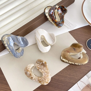 Elegant heart-shaped acetic acid hair claws in assorted vintage marble and tortoiseshell patterns