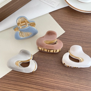 Heart-shaped acetate hair claws in Morandi colors with glossy finish and metal spring
