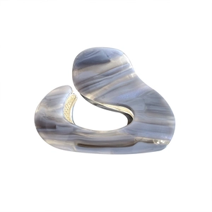 Minimalist marble texture acetate hair claw clip with golden spring on white background
