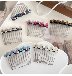 Elegant acetate flower hair combs in assorted colors on a minimalist display