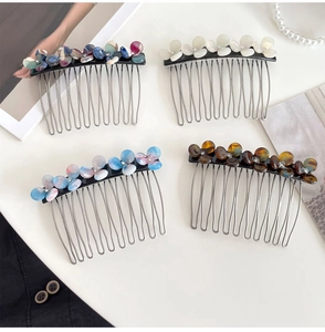 Detailed view of four acetate flower hair combs with marble and pearlescent patterns