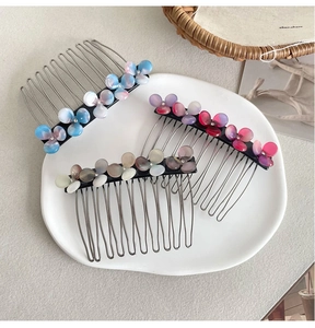 Detailed macro view of three acetate flower hair combs with marble texture and metal teeth