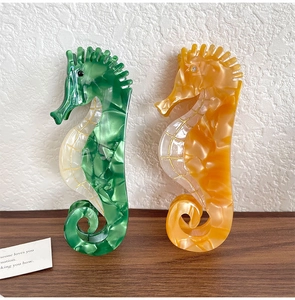 Détail de pinces à cheveux hippocampe en acétate marbré vert et jaune élégant
