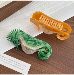 Vue détaillée des pinces à cheveux hippocampe en acétate avec motifs marbrés vert et ambre