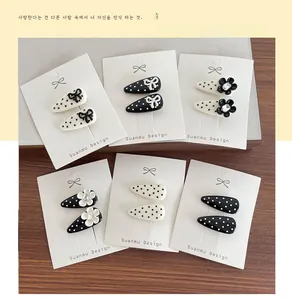 Polka dot hair clip set with bows and rhinestones displayed on wood background