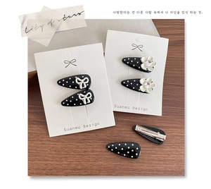Close-up of black and white polka dot hair clips with bow and flower designs