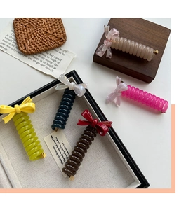Detail of colorful acetate bow hair clips with spiral design on aesthetic background