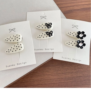 Detailed view of polka dot hair clips with elegant black bows and crystal flower accents