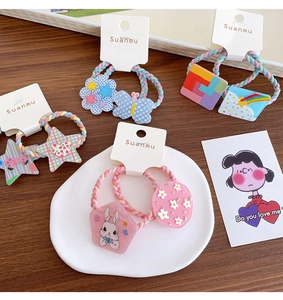 Detailed view of colorful elastic hair ties with acrylic rainbow and star charms for girls