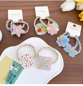 Close-up of colorful braided hair bands with acrylic flower and star charms for kids