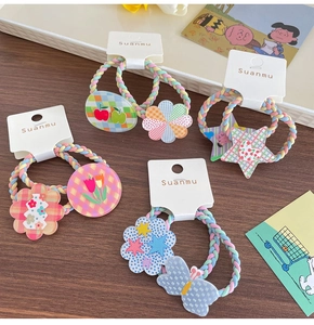 Detail of colorful knitted hair ties with acrylic flower and star charms on display