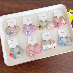 Detailed view of colorful elastic hair ties with acrylic flower and star charms for kids