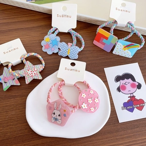 Set of 8 colorful cartoon hair ties for kids with stars and flowers on a wooden table
