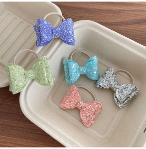 Gros plan de cinq élastiques à cheveux à paillettes en violet vert bleu rose argent