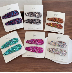 Lot de douze barrettes à paillettes de couleurs variées présentées sur des cartons