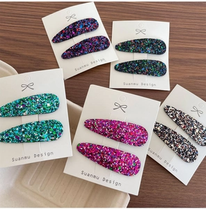 Gros plan de pinces à cheveux gouttes à paillettes colorées sur cartes blanches