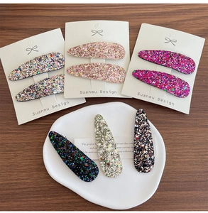 Gros plan de barrettes BB à paillettes de couleurs variées sur une surface en bois