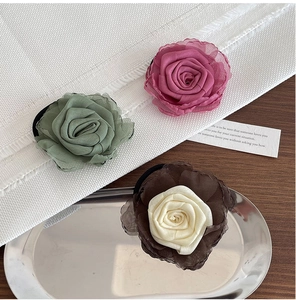 Vue détaillée d'élastiques à cheveux rose en mousseline rose et vert sur plateau