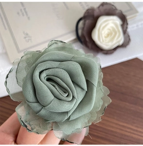 Texture détaillée de l'élastique à cheveux rose en mousseline vert sur fond élégant