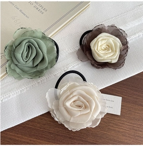 Détail de chouchous rose en mousseline multicouche aux tons vert, crème et café mat