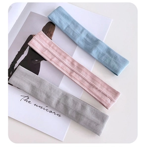 Close-up of three elastic ribbed knit headbands in sky blue, pink and grey colors