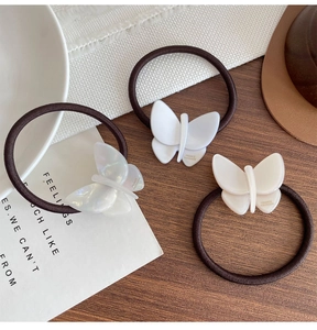 Detailed macro view of three acetate butterfly hair ties with France Handmade gold lettering