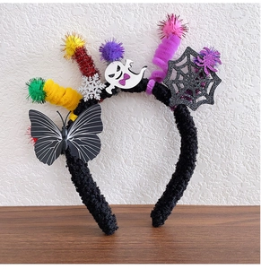 Detail of Halloween headband with cartoon ghost, glitter spider web and colorful pom poms