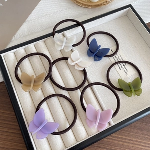 Elegant butterfly hair ties in seven pastel colors showcased in a professional display tray