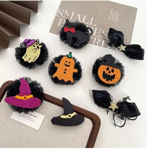 Detail view of assorted Halloween hair clips featuring glitter pumpkins and mesh ghosts