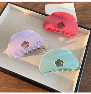 Vue détaillée des pinces à cheveux fleur ajourée en rose pastel, violet et vert menthe