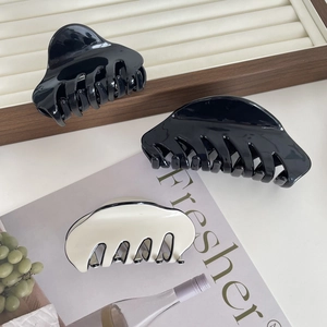 Classic French acetate hair claws in black and cream white for thick hair styling